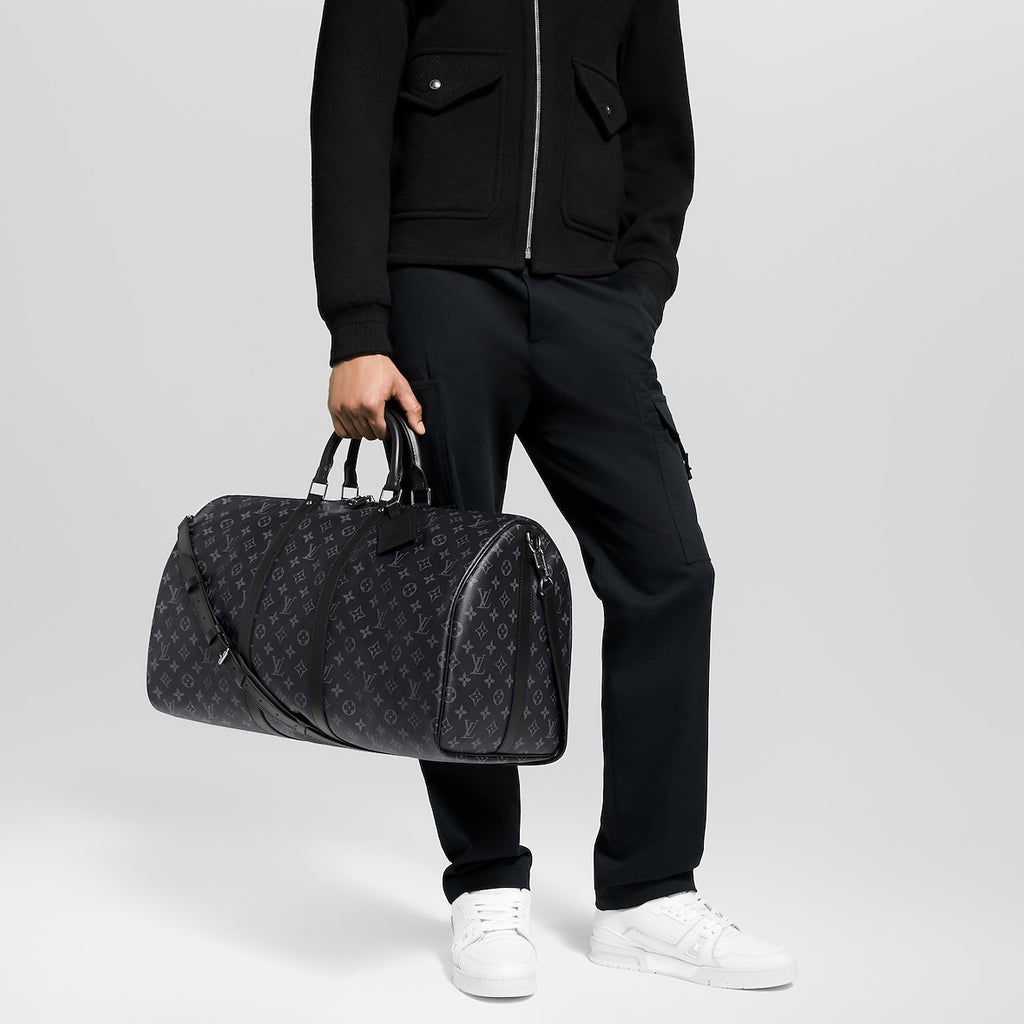 Athena™ Louis Vuitton Keepall Bandoulière 55 duffel bag with monogram canvas, leather trim, and adjustable shoulder strap.