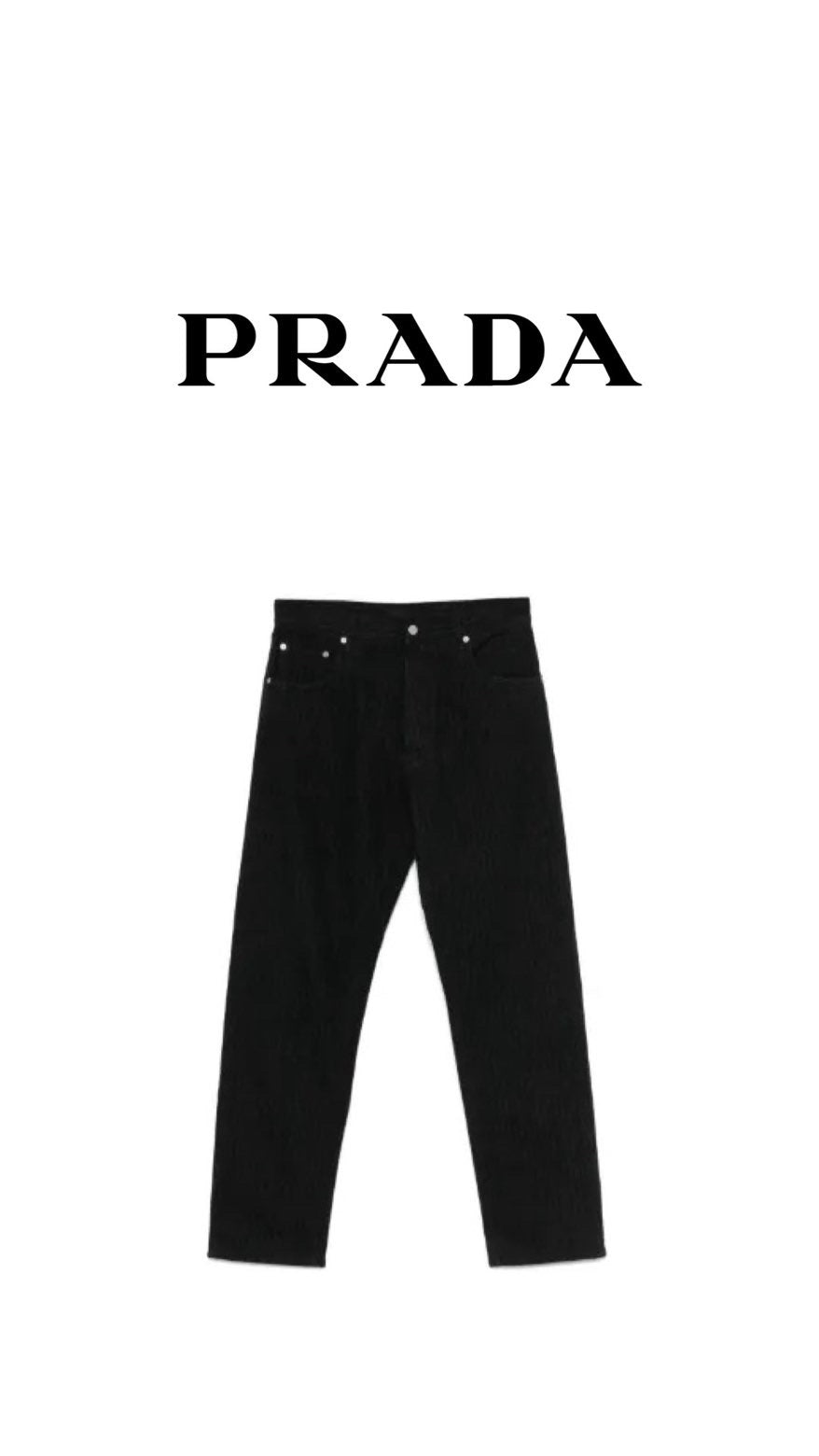 Athena™ Prada black stack jeans laid flat, showing slim fit and stacked leg design, made from denim fabric.