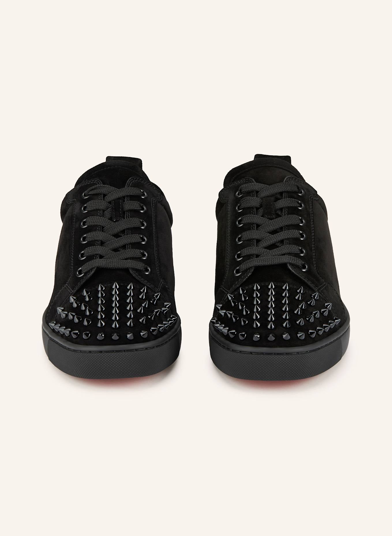 Christian Louboutin Junior sneakers by ATHENA ™ featuring red soles and stylish design, showcased in a close-up image.
