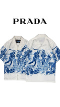 Athena™ Prada Important Ones button-up shirt in crisp fabric, featuring classic collar and button details, laid flat.
